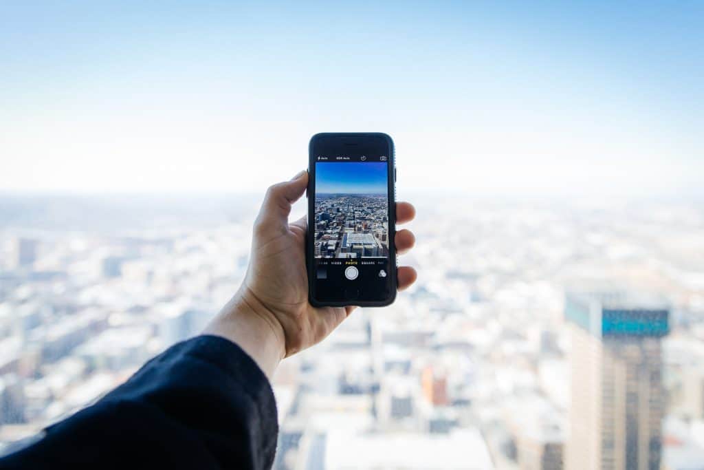 An iphone taking a photo of a city skyline. 